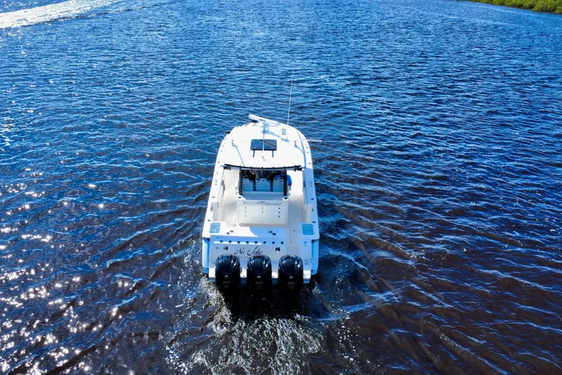 No Joke Yacht Photos Pics 2022 Robalo R360 Center Console boat cruising on open water, rear view.