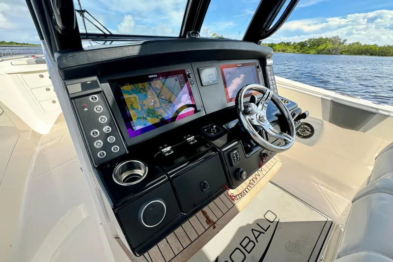 No Joke Yacht Photos Pics 2022 Robalo R360 Center Console boat dashboard with navigation screens and steering wheel.