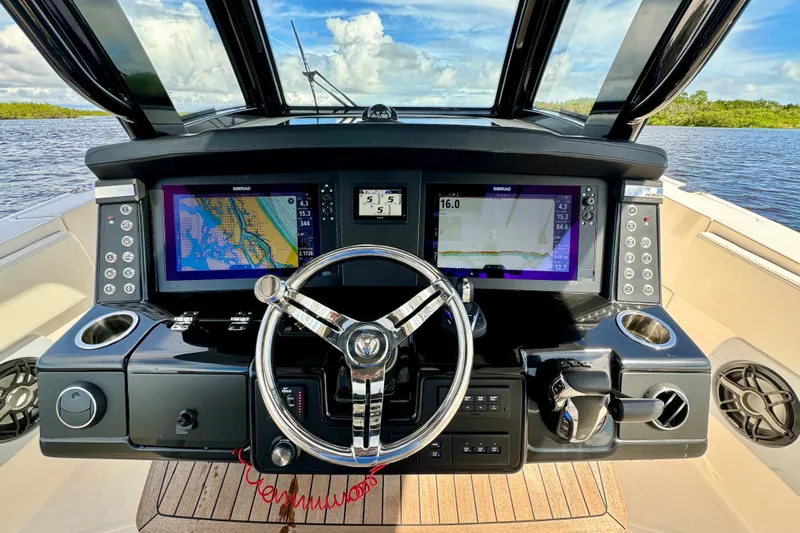 No Joke Yacht Photos Pics 2022 Robalo R360 Center Console helm with dual navigation screens and steering wheel.