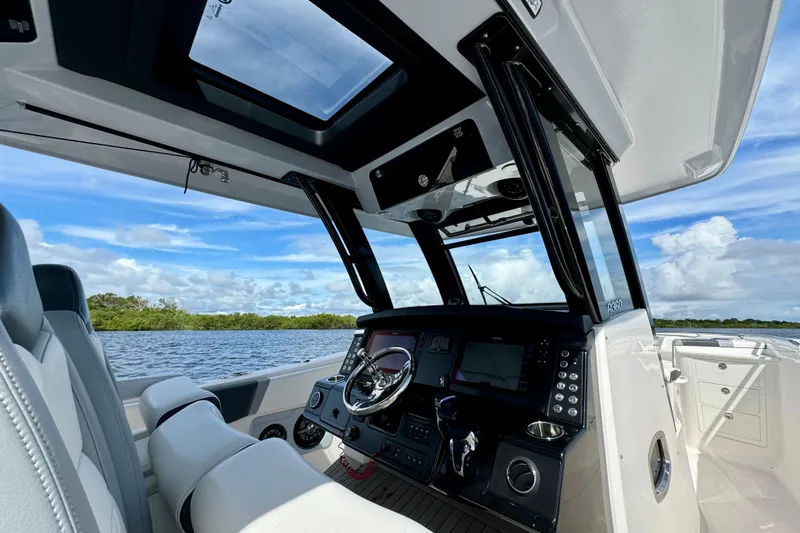 No Joke Yacht Photos Pics 2022 Robalo R360 Center Console boat interior with modern dashboard and scenic water view.