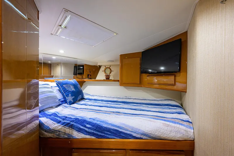 Alli-gator Yacht Photos Pics Luxurious cabin interior of 2000 Viking 50 Convertible yacht with cozy bedding and TV.