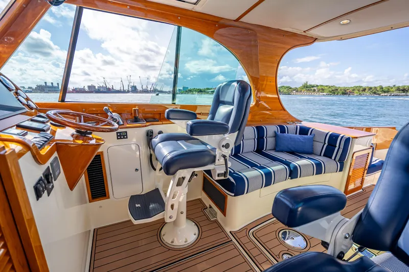 Gracious Yacht Photos Pics 2018 Hinckley Picnic Boat 37 MKIII interior with striped seating and helm, overlooking water.