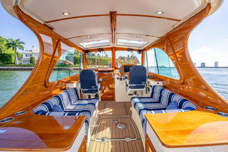 Gracious Yacht Photos Pics Luxurious 2018 Hinckley Picnic Boat 37 MKIII interior with elegant wood finish and striped seating.