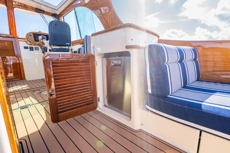 Gracious Yacht Photos Pics Interior of 2018 Hinckley Picnic Boat 37 MKIII with striped seating and wooden finishes.