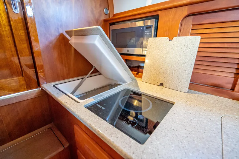 Gracious Yacht Photos Pics Hinckley Picnic Boat 37 MKIII 2018 galley with stove, sink, and microwave.