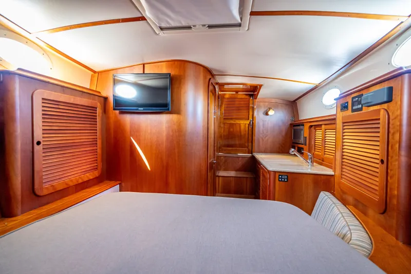 Gracious Yacht Photos Pics 2018 Hinckley Picnic Boat 37 MKIII interior with wood finish, TV, and kitchenette.