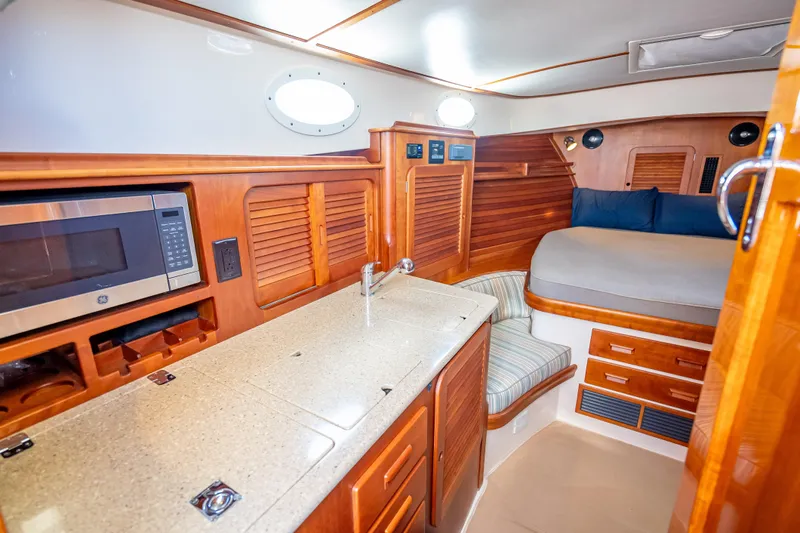 Gracious Yacht Photos Pics 2018 Hinckley Picnic Boat 37 MKIII interior with kitchenette and cozy sleeping area.