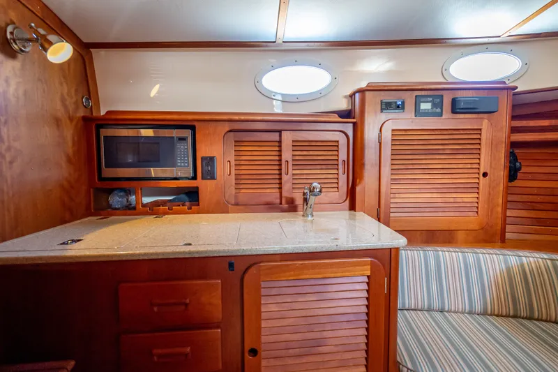 Gracious Yacht Photos Pics Interior of 2018 Hinckley Picnic Boat 37 MKIII with wooden cabinetry and modern amenities.
