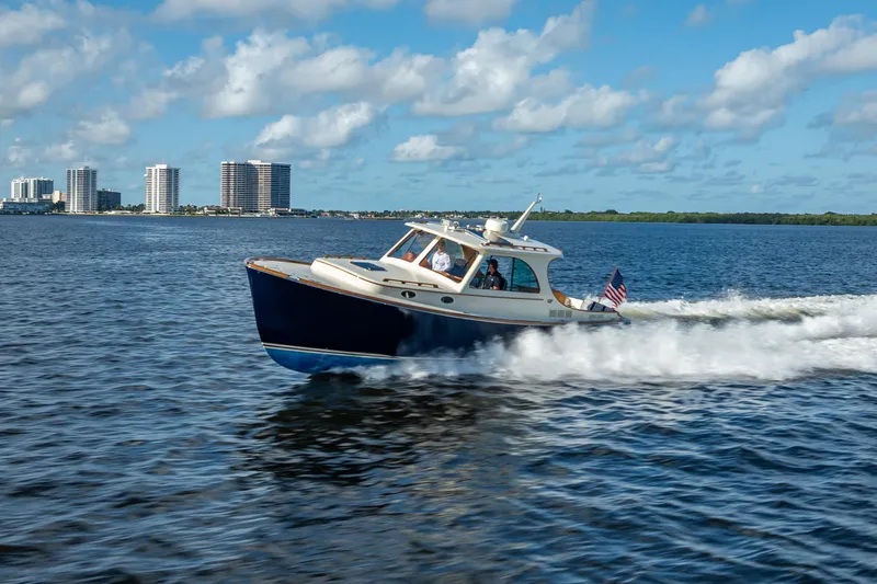 Gracious Yacht Photos Pics 2018 Hinckley Picnic Boat 37 MKIII cruising on water with city skyline in background.