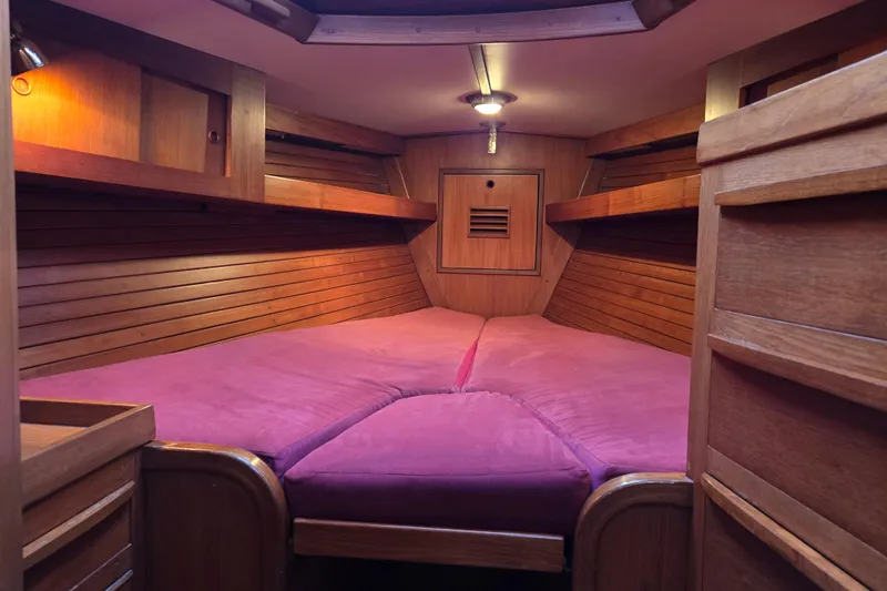 Simplicity Yacht Photos Pics Cozy wooden cabin interior of 1986 Cambria 46 sailboat with pink bedding.