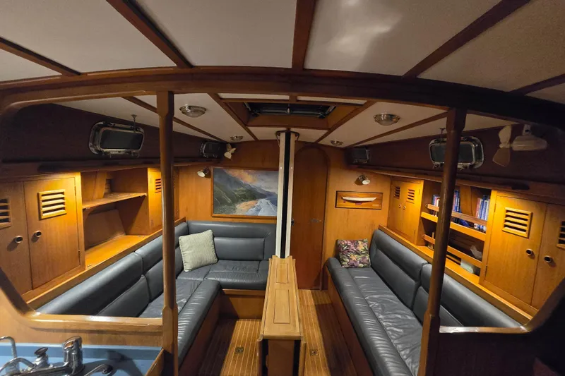 Simplicity Yacht Photos Pics Interior of 1986 Cambria 46 yacht with wooden furnishings and blue seating.