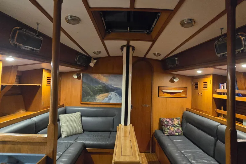 Simplicity Yacht Photos Pics Interior of 1986 Cambria 46 sailboat with wood paneling and cozy seating area.
