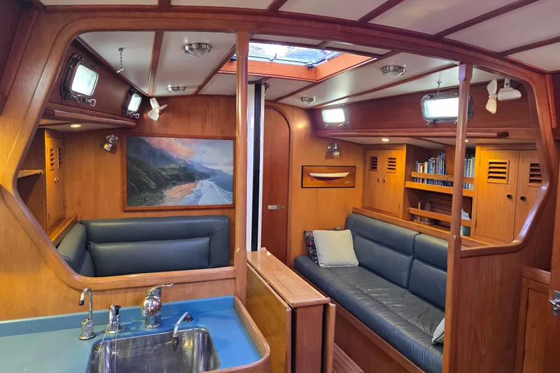 Simplicity Yacht Photos Pics Interior of 1986 Cambria 46 yacht with wood paneling and blue seating.