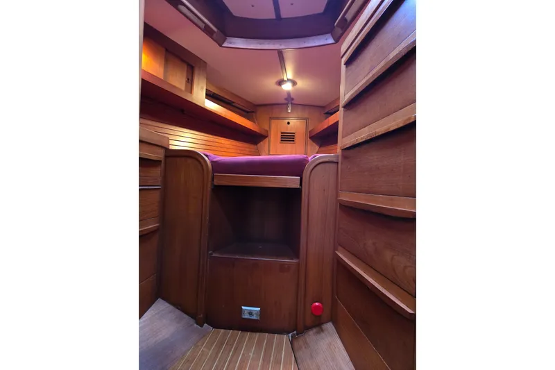 Simplicity Yacht Photos Pics Interior of 1986 Cambria 46 sailboat with wooden cabinetry and cozy sleeping area.