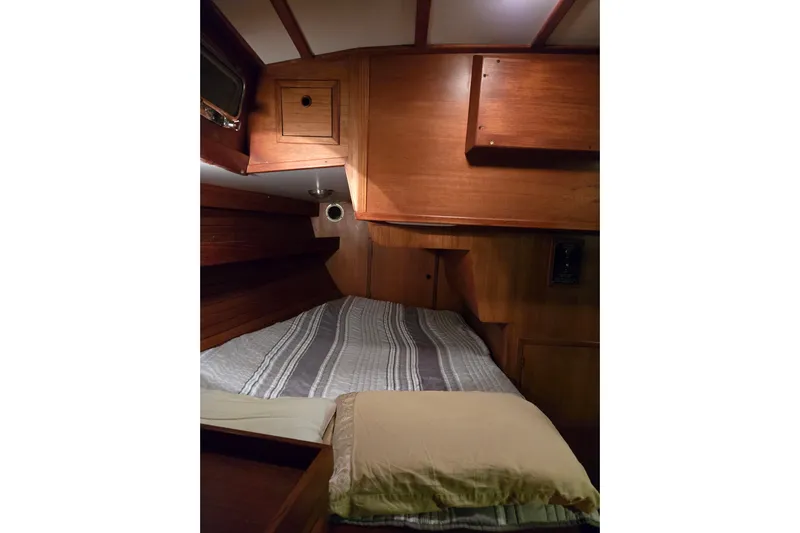 Simplicity Yacht Photos Pics Cozy wooden cabin interior of 1986 Cambria 46 sailboat with bed and storage.
