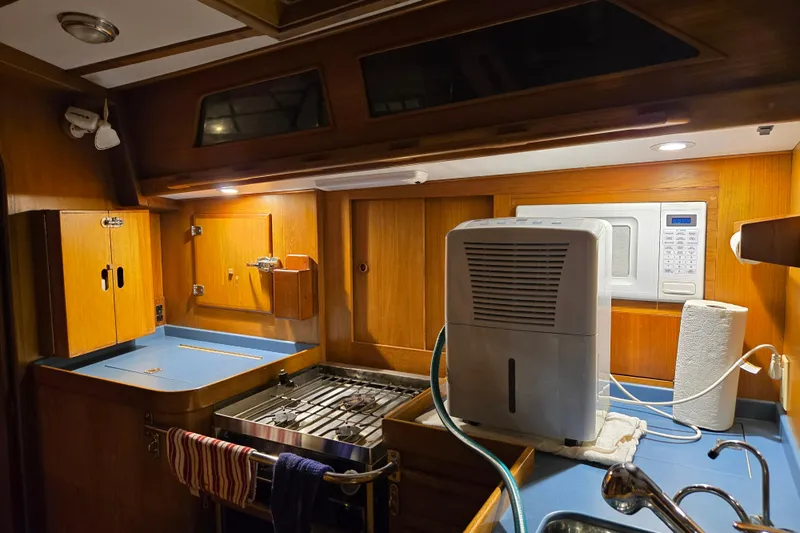 Simplicity Yacht Photos Pics Compact kitchen in 1986 Cambria 46 yacht with stove, microwave, and dehumidifier.