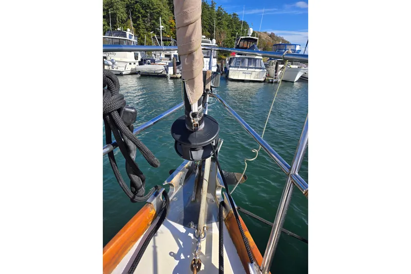 Simplicity Yacht Photos Pics Bow of 1986 Cambria 46 sailboat docked in marina, surrounded by water and other boats.
