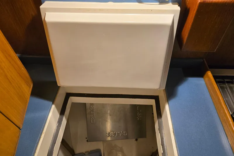 Simplicity Yacht Photos Pics Cambria 46 (1986) yacht interior with open storage compartment and wooden cabinetry.