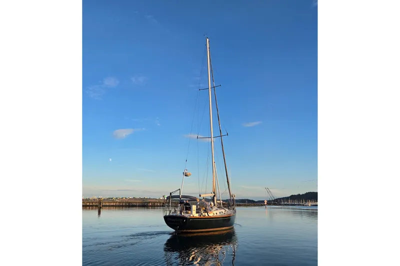 Simplicity Yacht Photos Pics Sailboat Cambria 46 from 1986 on calm water under clear blue sky.