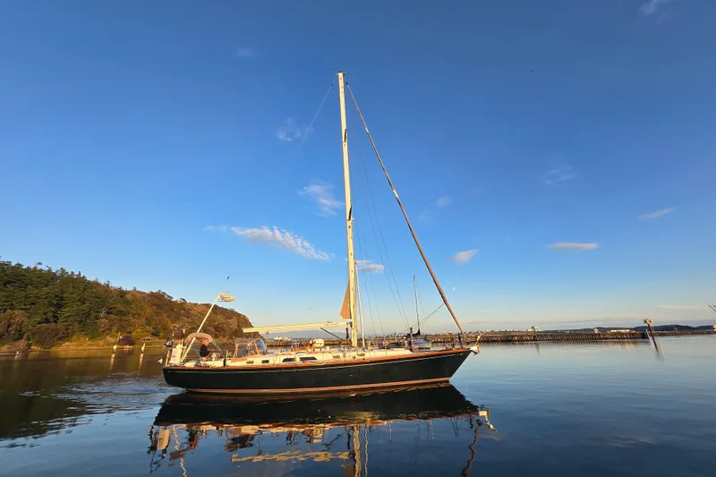 Simplicity Yacht Photos Pics 1986 Cambria 46 sailboat on calm water under clear blue sky.
