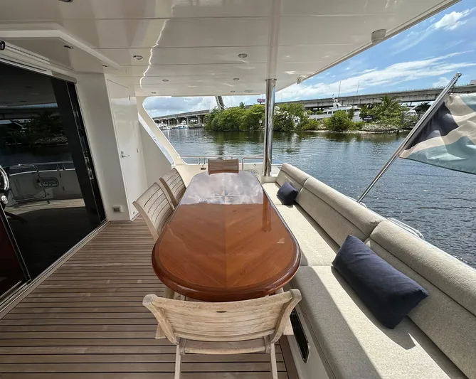 Unicorn Yacht Photos Pics Luxury yacht deck with elegant dining area, featuring wooden table and cushioned seating. Hampton 658l Endurance 2020.