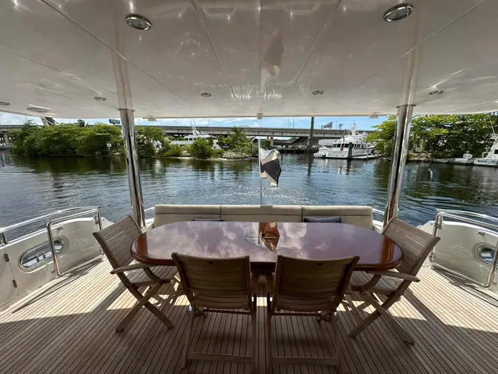 Unicorn Yacht Photos Pics Outdoor dining area on 2020 Hampton 658l Endurance yacht, overlooking serene waterfront view.