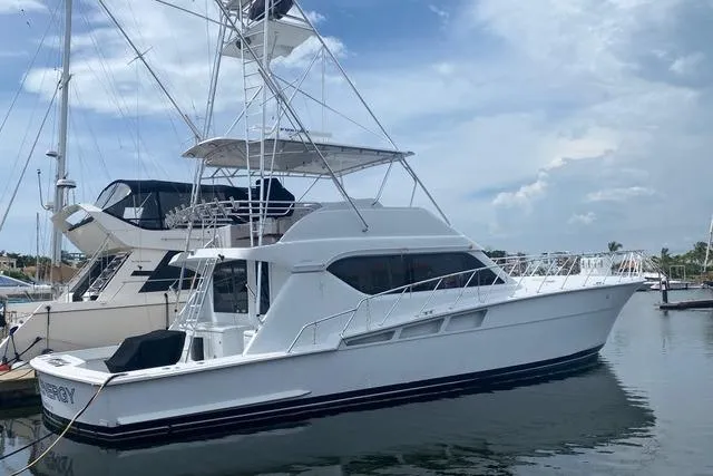  Yacht Photos Pics 2001 Hatteras 60 Convertible yacht docked at marina under cloudy sky.