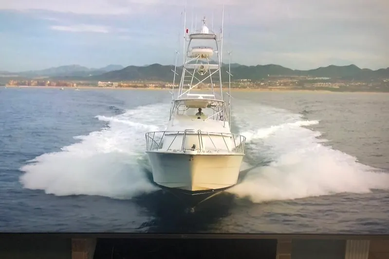  Yacht Photos Pics 2001 Hatteras 60 Convertible yacht cruising on open water with scenic mountain backdrop.