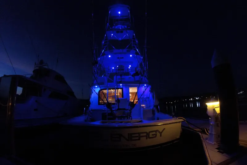  Yacht Photos Pics 2001 Hatteras 60 Convertible yacht illuminated with blue lights at night.