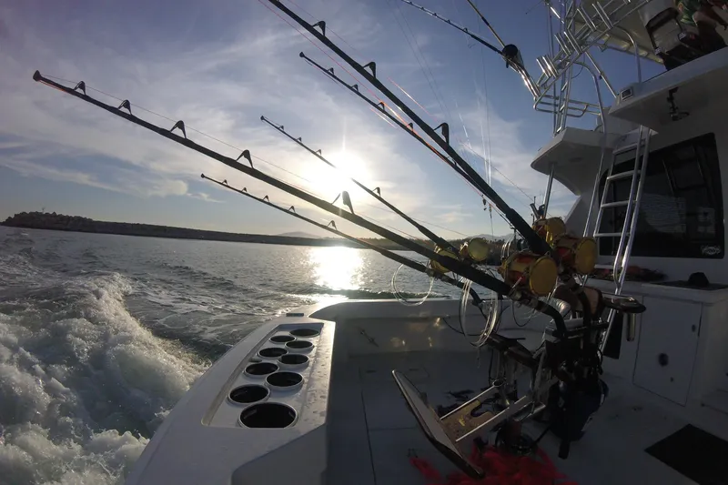  Yacht Photos Pics Fishing rods on a 2001 Hatteras 60 Convertible boat at sunset.