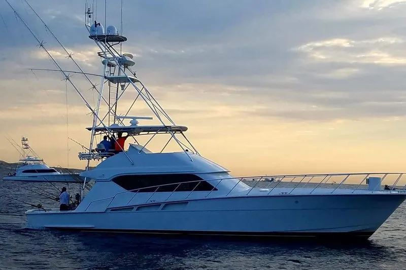  Yacht Photos Pics 2001 Hatteras 60 Convertible yacht on calm sea at sunset.