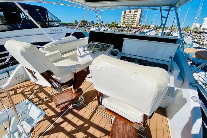  Yacht Photos Pics Helm of 2001 Hatteras 60 Convertible yacht with white seats and control panel.