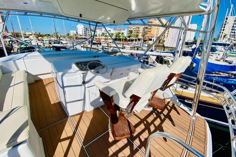  Yacht Photos Pics 2001 Hatteras 60 Convertible yacht helm with white seats and marina view.