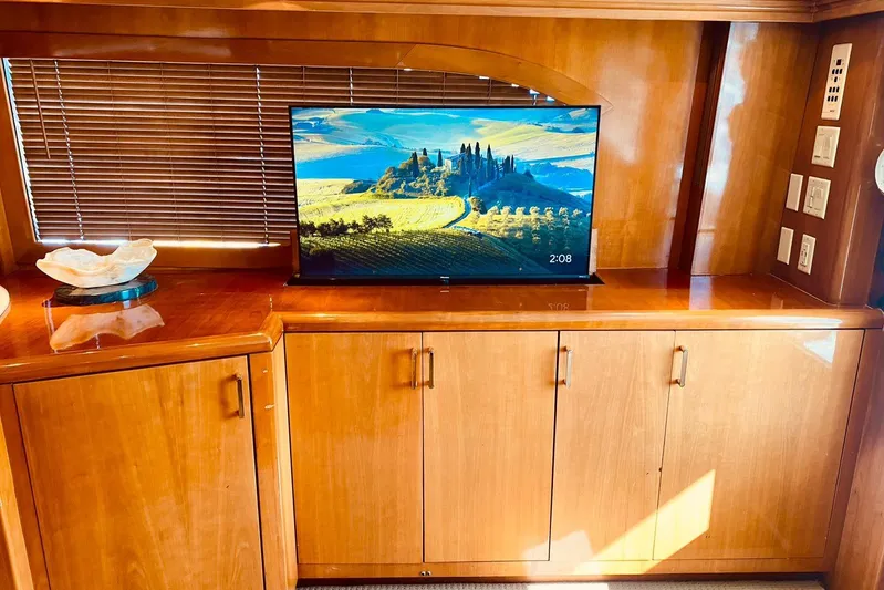  Yacht Photos Pics Luxurious interior of 2001 Hatteras 60 Convertible yacht with TV and wooden cabinetry.