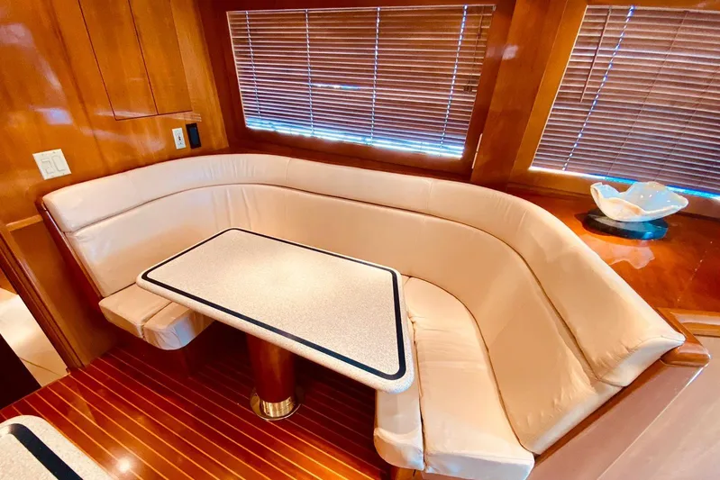  Yacht Photos Pics Luxurious dining area in 2001 Hatteras 60 Convertible yacht with leather seating and wooden accents.