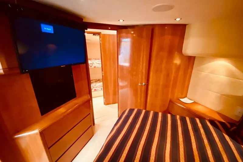  Yacht Photos Pics Luxurious cabin interior of 2001 Hatteras 60 Convertible yacht with wood finishes and TV.