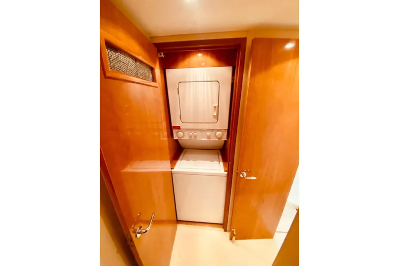  Yacht Photos Pics Laundry area with stacked washer and dryer in 2001 Hatteras 60 Convertible yacht.