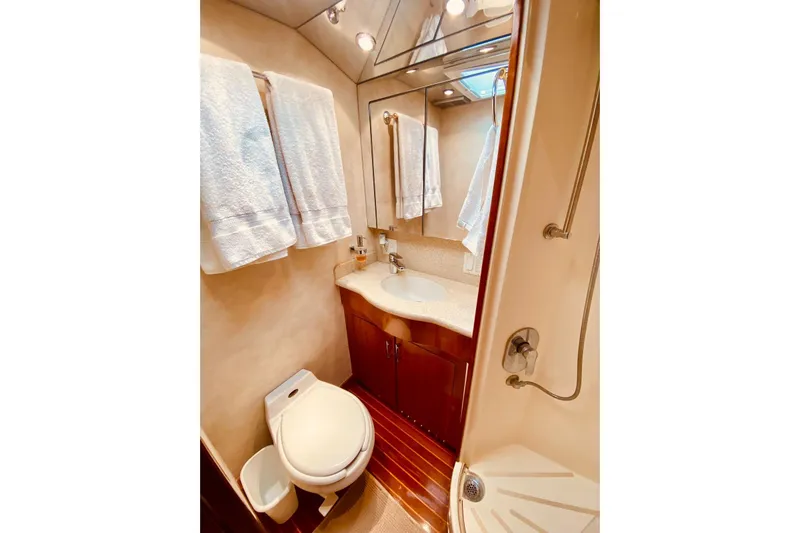  Yacht Photos Pics Luxurious bathroom in 2001 Hatteras 60 Convertible yacht with elegant fixtures and wood accents.