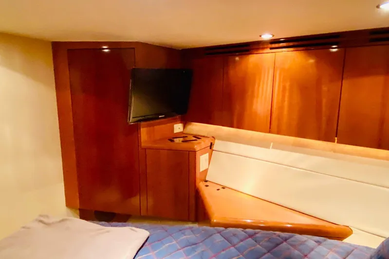  Yacht Photos Pics Luxurious cabin interior of 2001 Hatteras 60 Convertible yacht with wood paneling and TV.