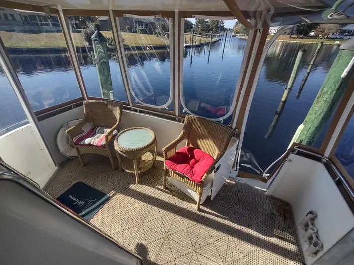  Yacht Photos Pics 2004 Carver 366 Motor Yacht interior with wicker chairs and table, overlooking serene waterway.