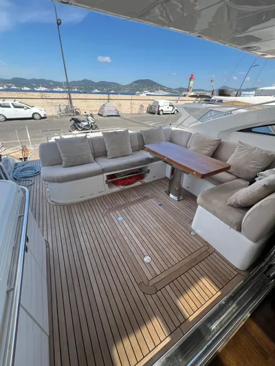  Yacht Photos Pics Luxurious 2011 Princess V62 yacht deck with cushioned seating and wooden table.