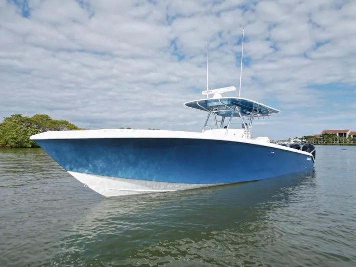  Yacht Photos Pics 2013 Bahama Open Fisherman boat on calm water under a cloudy sky.
