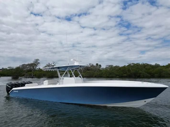  Yacht Photos Pics 2013 Bahama Open Fisherman boat on calm water with cloudy sky background.