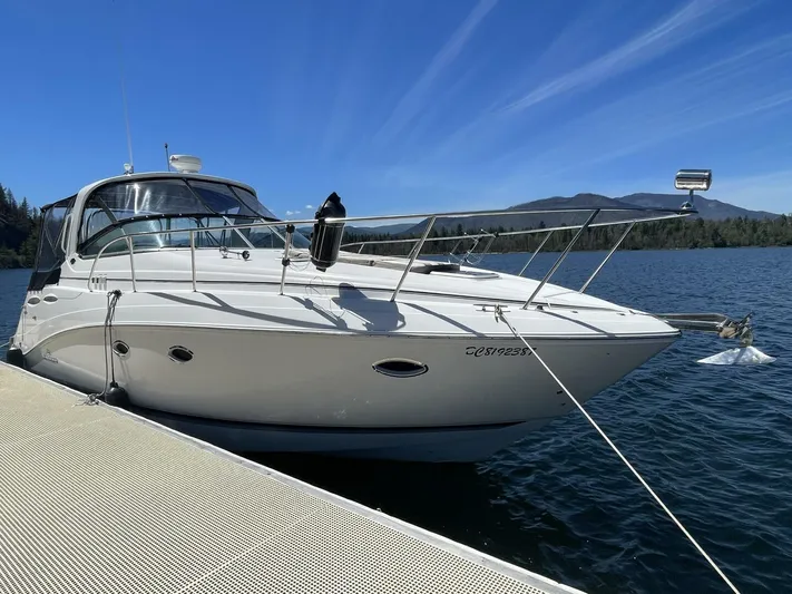  Yacht Photos Pics 2007 Rinker 350 Express Cruiser docked on a serene lake under a clear blue sky.