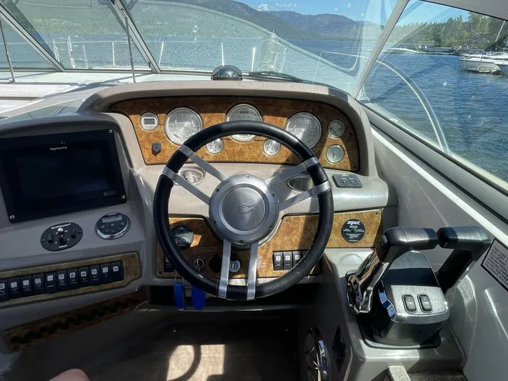  Yacht Photos Pics 2007 Rinker 350 Express Cruiser helm with gauges, steering wheel, and throttle controls on a sunny day.