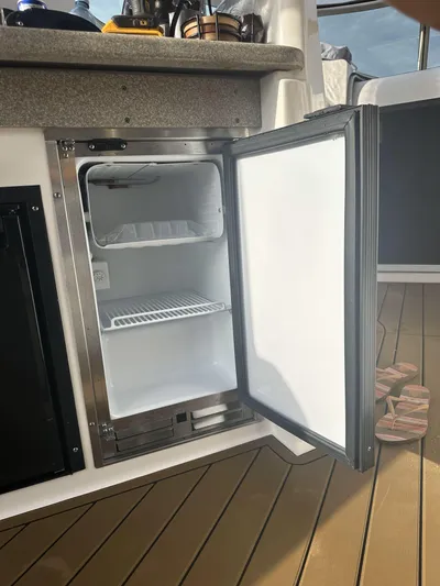  Yacht Photos Pics Open mini fridge on 2007 Rinker 350 Express Cruiser boat, showing interior shelves.