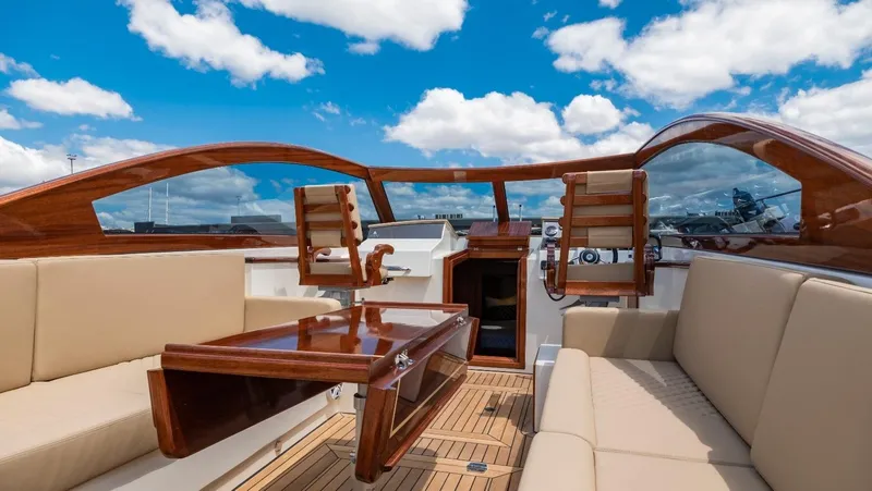  Yacht Photos Pics 2023 Vento V40 Retro Classic Open boat interior with wooden accents and beige seating under blue sky.