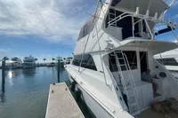1999 Viking 58 EB yacht docked at marina under clear blue sky.