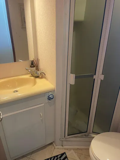  Yacht Photos Pics Compact bathroom in a 1999 Viking 58 EB yacht with shower, sink, and toilet.