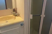 Compact bathroom in a 1999 Viking 58 EB yacht with shower, sink, and toilet.